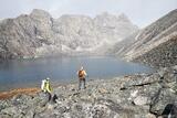 Backpackers offtrail hiking over rocks, Arrigetch Peaks