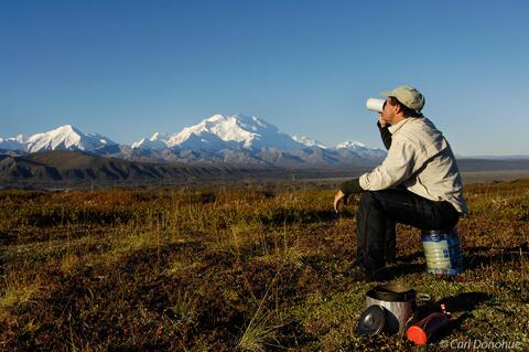 A backpacker takes a break for breakfast, with a grand view of M
