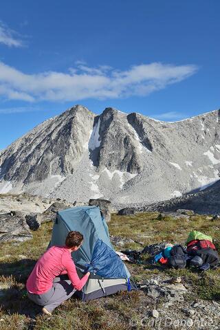 Woman backpacker setting up tent Chugach Mountains