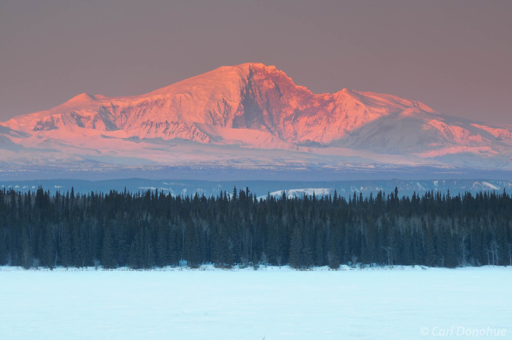 Mount Sanford rises above the Wrangell Mountains, catching the last rays of the day. Alpenglow on Mt Sanford, above Willow Lake...