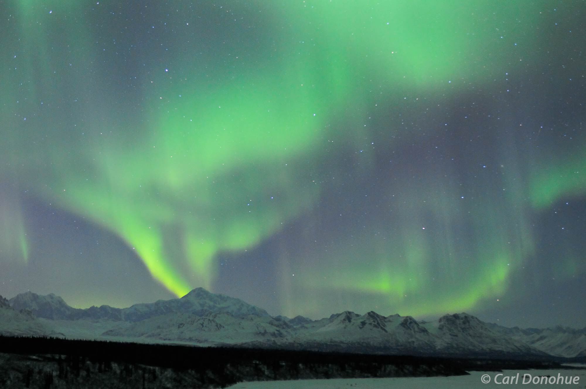 Aurora borealis lights up the winter night sky over Mt Denali, highest mountain in North America, recently called Mt McKinley...