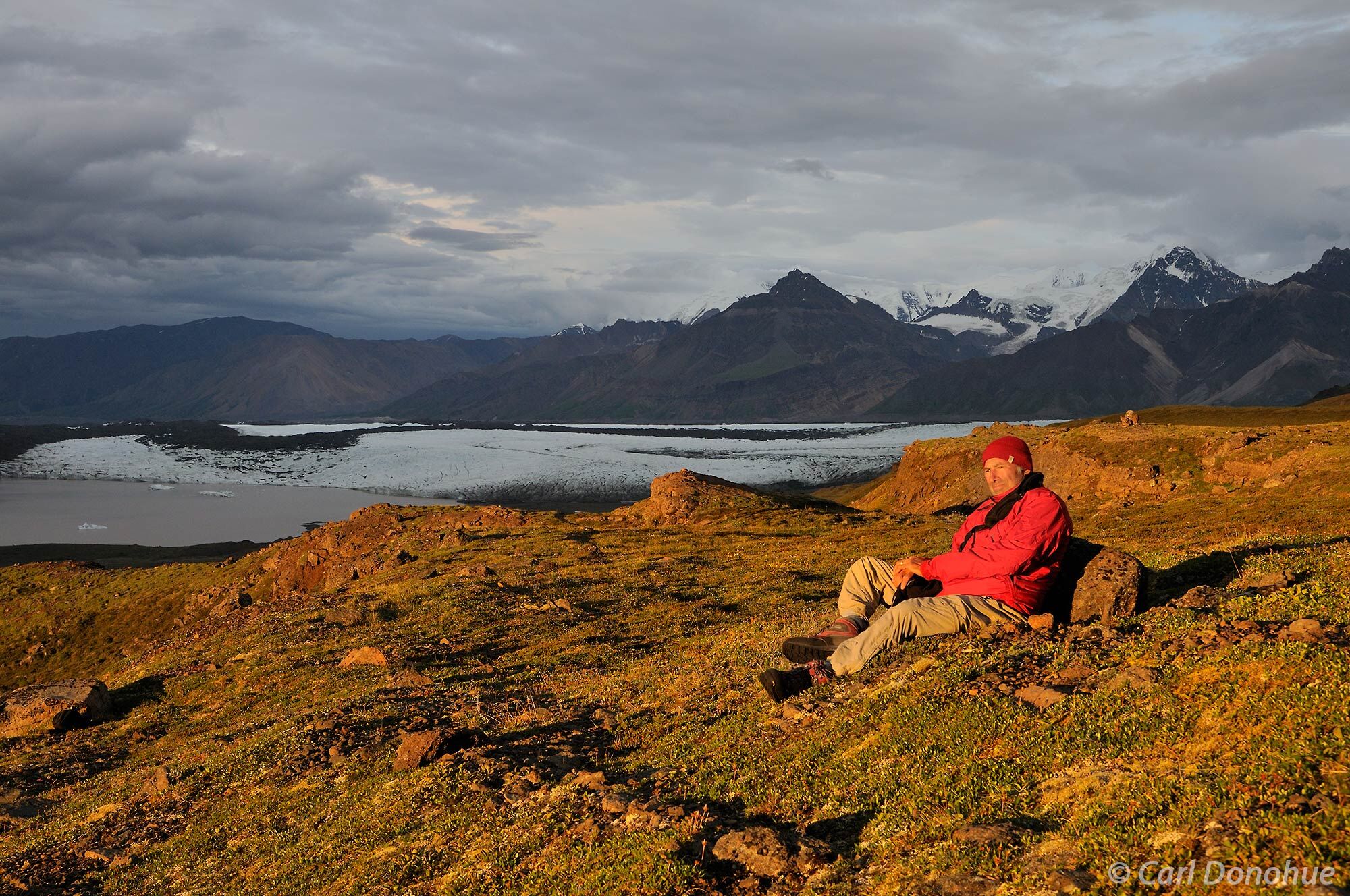 Hiker or backpacker, resting at camp, and soaking in the mountain wilderness of Chitistone Pass, Wrangell-St. Elias National...