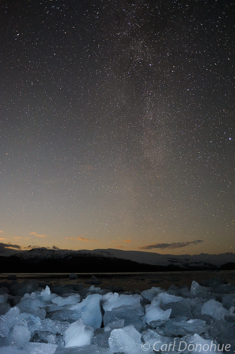 Milky Way over Guyot Hills and Icy Bay. Icebergs lie on the shore of icy Bay, as the Milky Way glows over a sunset sky. Wrangell...