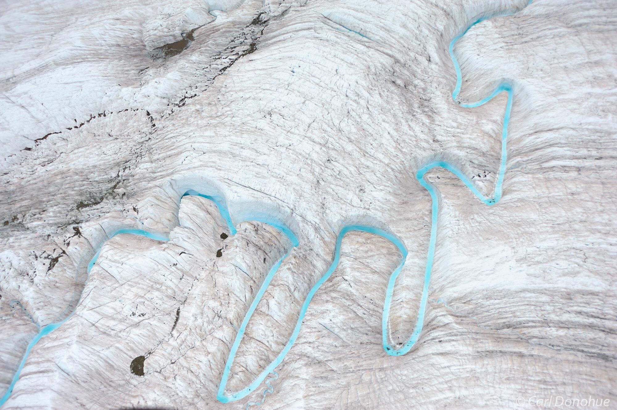 Aerial photo of Root Glacier and a small turquoise glacial stream, Wrangell-St. Elias National Park and Preserve, Alaska.