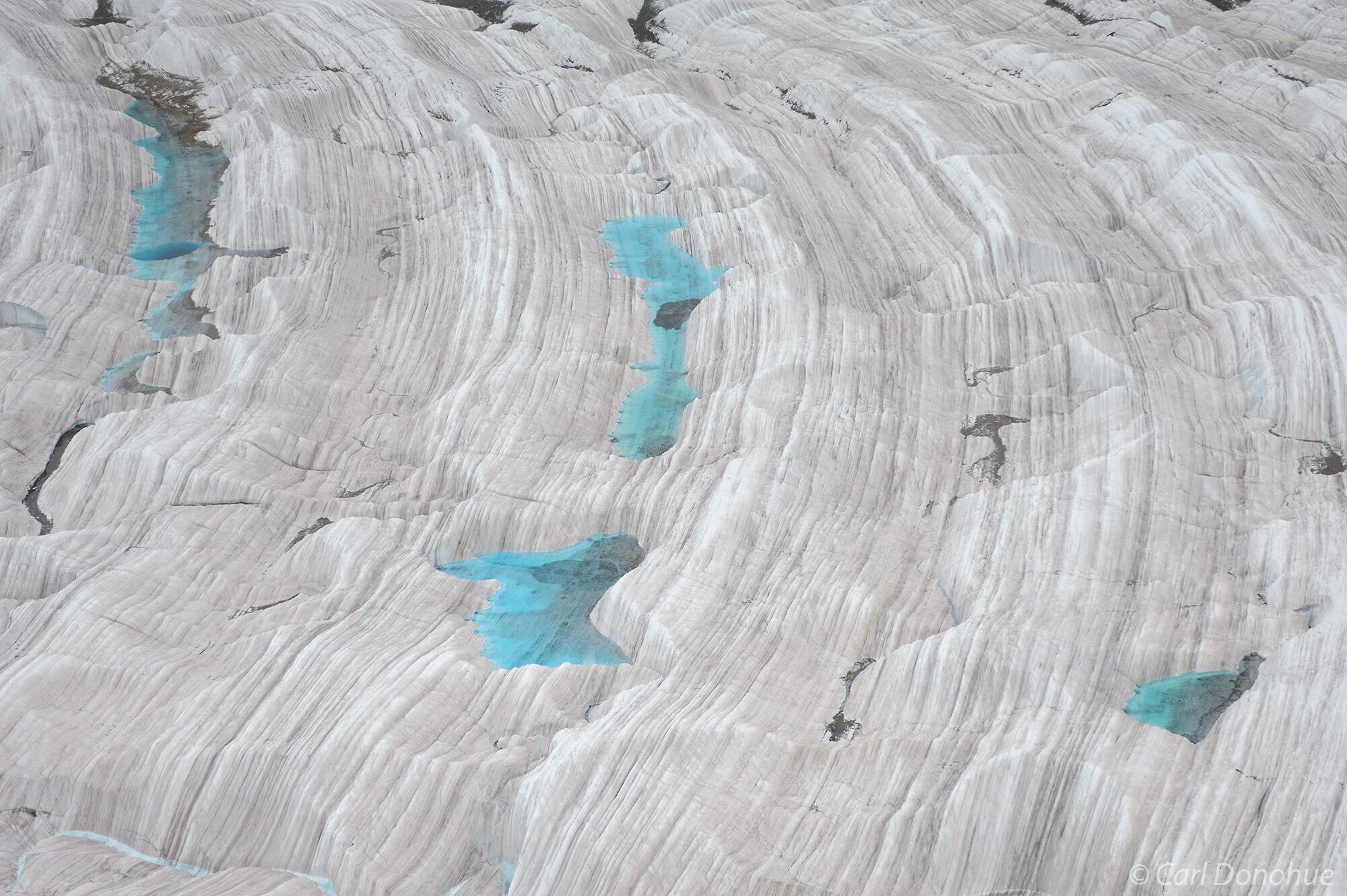 Small turquoise ponds, or tarns, dot the surface of Root Glacier, near Kennicott Glacier, Wrangell - St. Elias National Park...