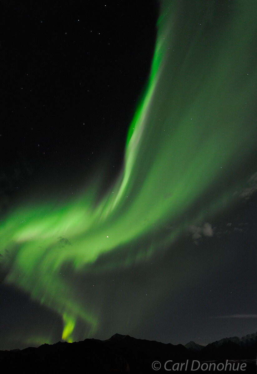 Northern lights light up the night sky over the Chugach Mountains an Matanuska Glacier, Glenn Highway, Alaska.