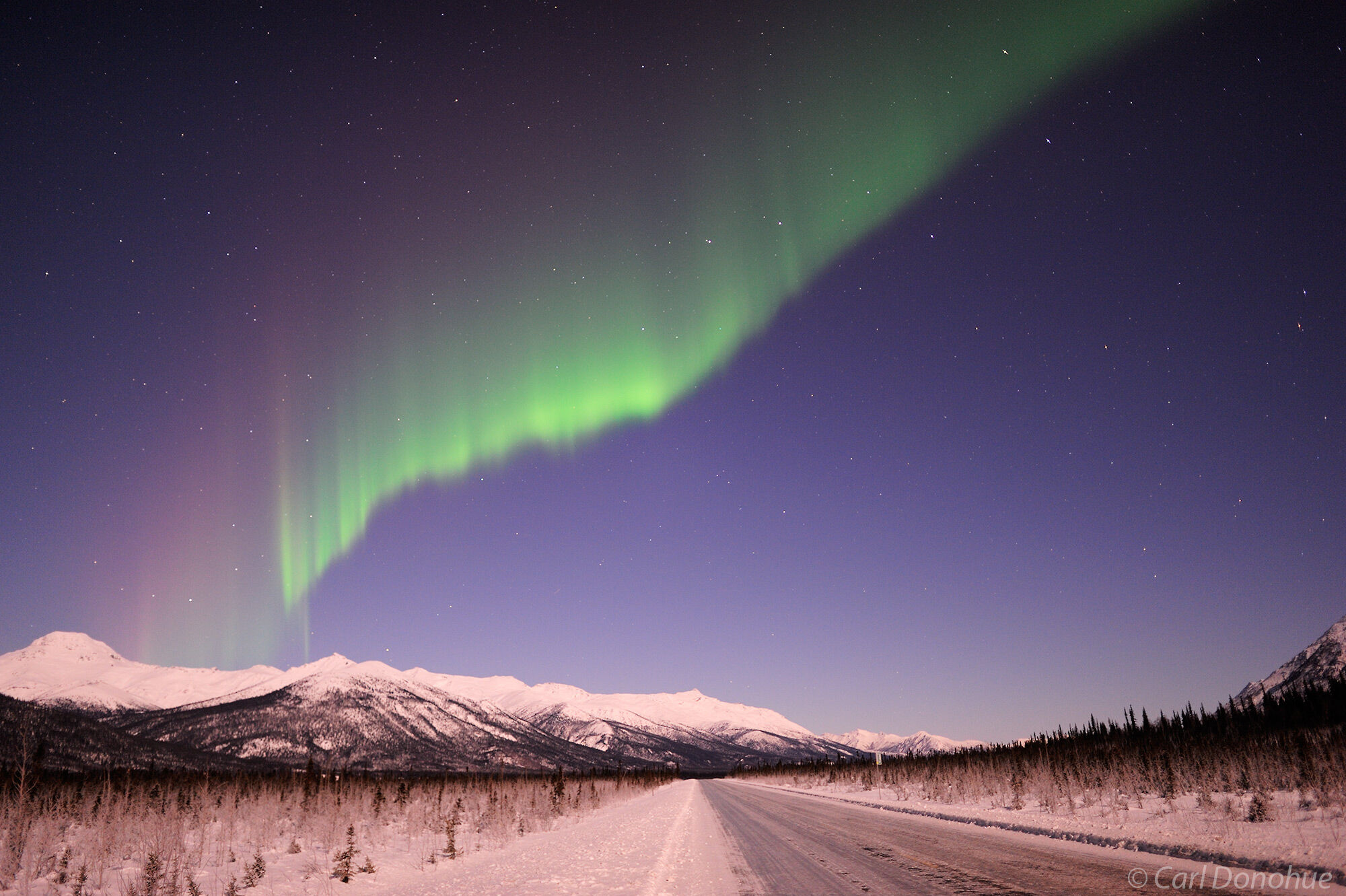 A stock photo of the northern lights over the Dalton highway, with the Brooks Range mountains in the background, part of Gates...