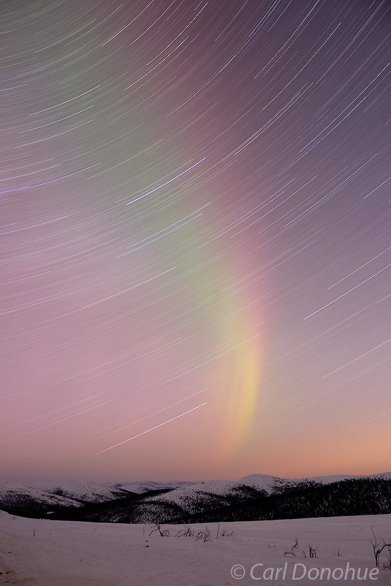 Aurora borealis photo, or northern lights, with star trails against the northern night sky in sub-arctic Alaska.