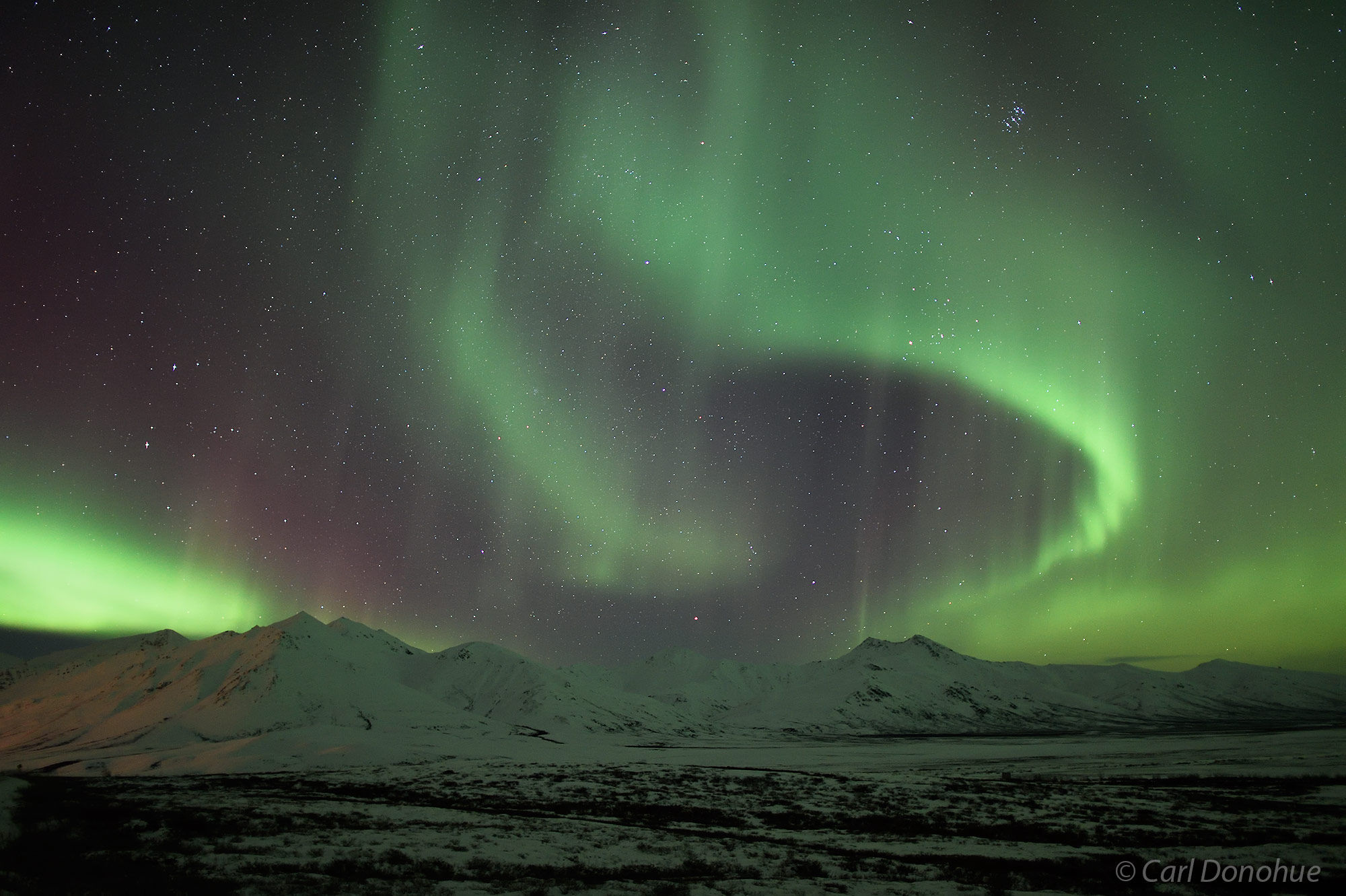 In Arctic Alaska near Atigun Pass the northern lights stretch across the sky over the Brooks Mountain Range. This photo was taken...