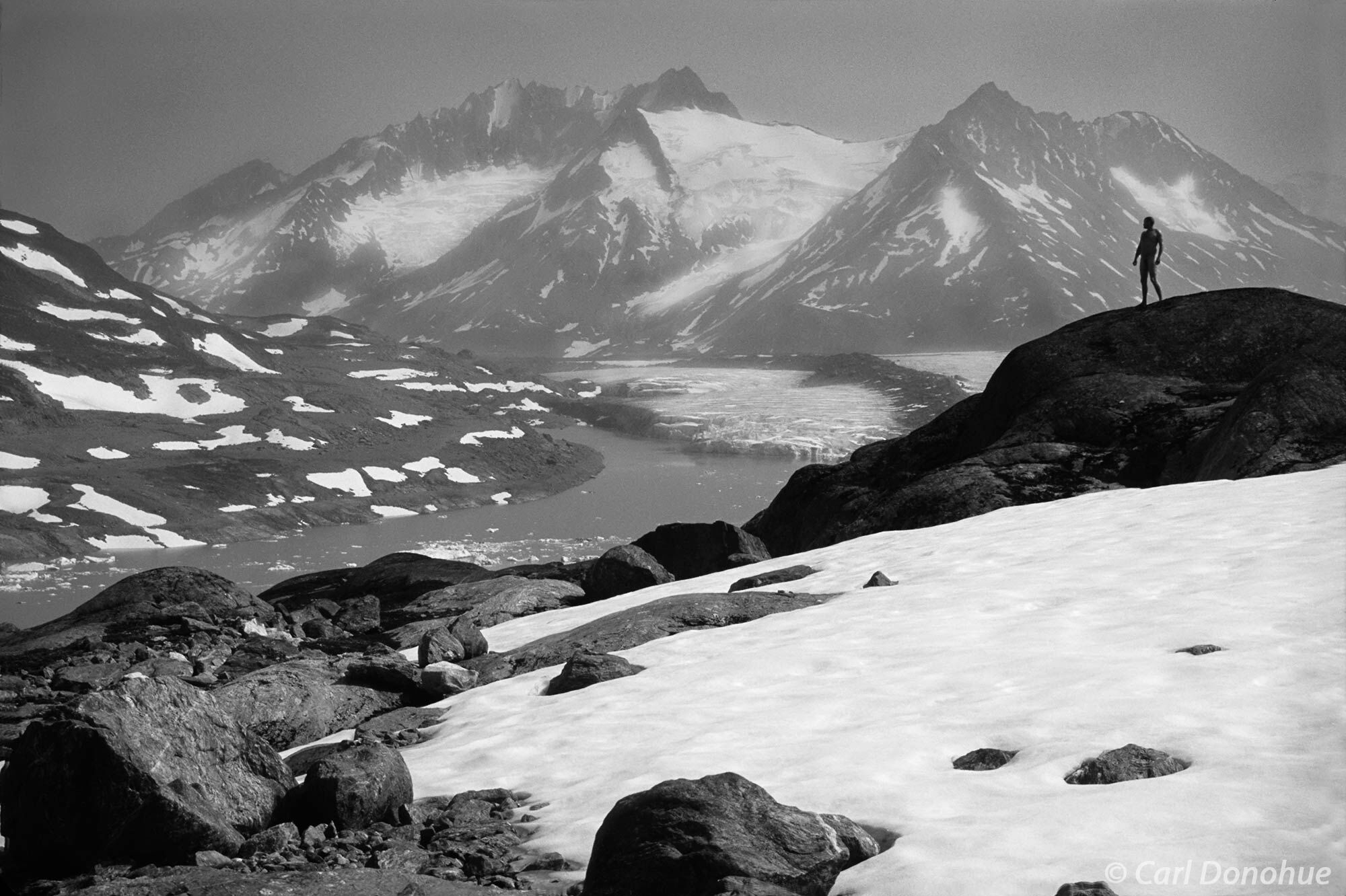 Black and white photo, silhouette of a naked man against the glaciers and snow-capped peaks of the Chugach Range. Alaska Adventure...