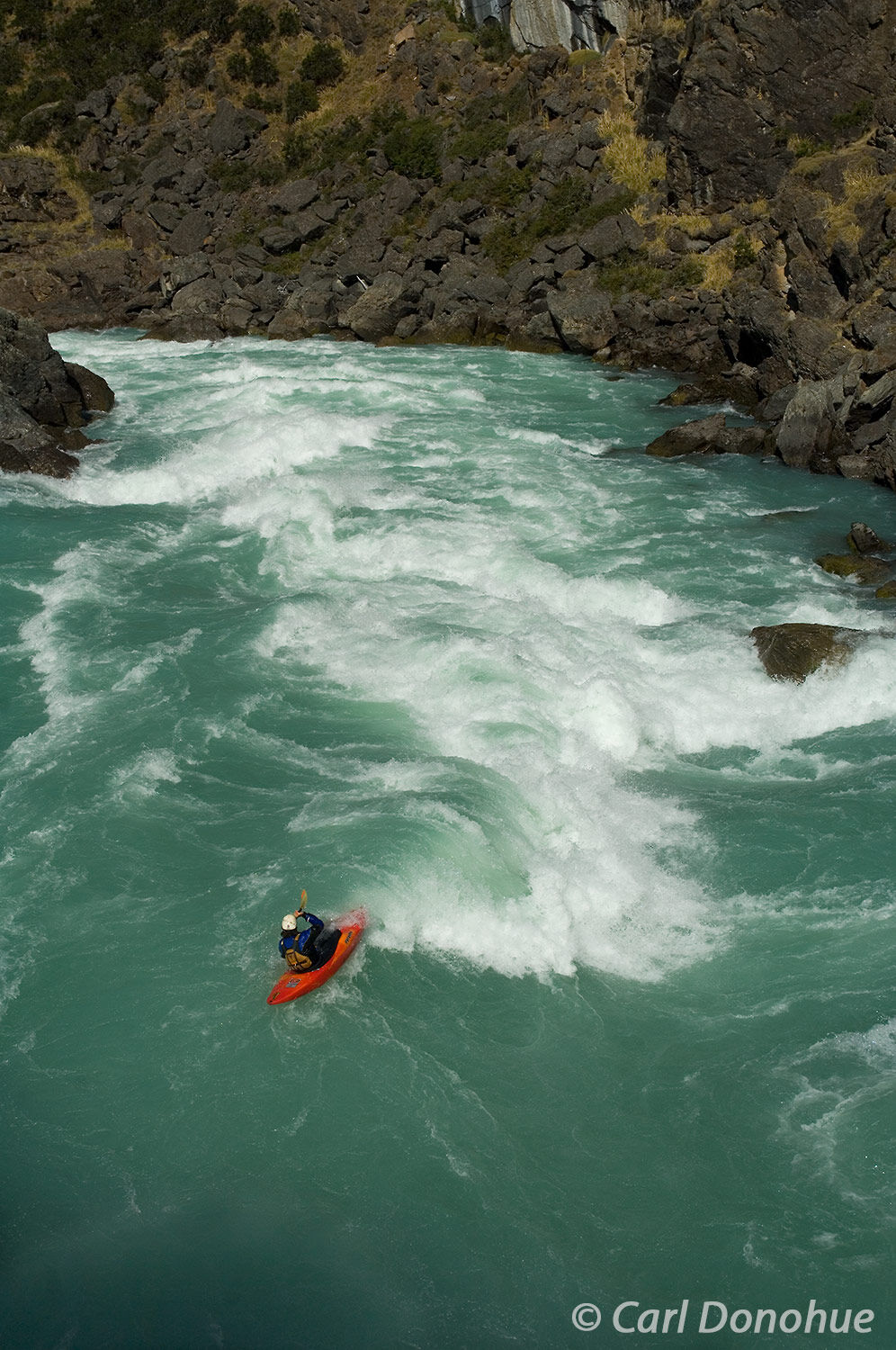 Whitewater kayaking on the Baker River. The 2nd rapid in the canyon, this huge river dwarfs a kayaker as he navigates his way...