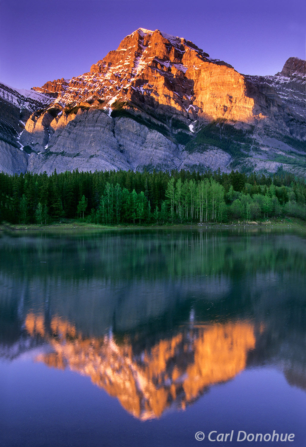 Mount Kidd at dawn. Reflections in Wedge Pond and dawn's alpenglow light up Mount Kidd, Upper Kananaskis Lakes, Day Use area...